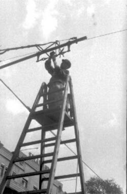 Ein Elektriker hantiert an einem Oberleitungsmast