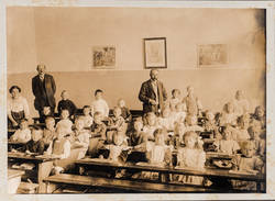 Gruppenbildnis einer gemischten Klasse im Klassenraum mit Lehrern