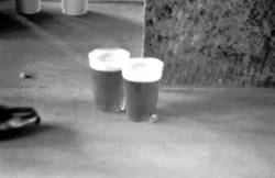 o.T.,  zwei auf dem Boden abgestellte Plastik-Bier-Becher