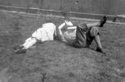 Junges Paar liegt in der Sonne auf der Grünfläche eines Vorgartens