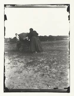 Zwei Frauen mit reisigbeladenem Handkarren und Kinderwagen