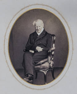 Alexander von Humboldt auf dem Stuhle sitzend;