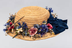 Damenstrohhut mit Blumengarnierung und blauer Samtschleife