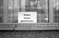 o.T.,  Schild "Wegen Urlaub geschlossen" im Fenster einer Kneipe
