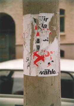 Wahlwerbung zur Bundestagswahl 1990. Mehrfach abgerissene und überklebte Plakate an Laternenmast