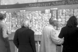 Bürger studieren die an einer Kreuzberger Inseraten-Wand aushängenden Anzeigen