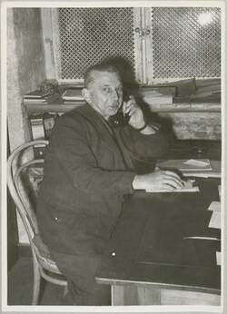 Nadlermeister Becker, telefonierend am Schreibtisch