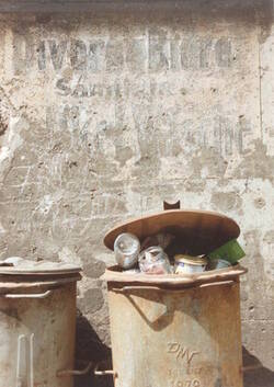 Mülltonnen in einem Hinterhof vor Wand mit verwitterter Schrift "Diverse Biere"