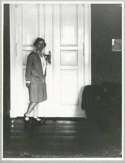 Junge Frau, an Zimmertür stehend