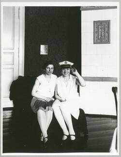 Zwei junge Frauen, auf Chaiselongue sitzend