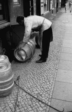 o.T., Straßenszene. Anlieferung/Einlagerung von  Bier-Fässern in den Keller einer Kneipe