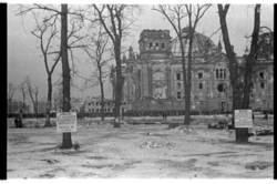 Reichstagsgebäude und Schwarzmarkt, im Vordergrund viersprachige Warnschilder, die auf das Verbot des Handelns mit alliierten Soldaten hinweisen; Tiergarten, britischer Sektor