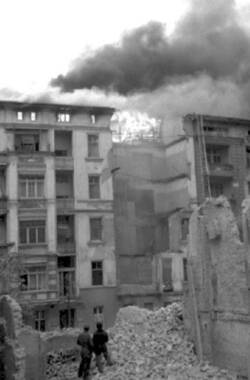 Propangasexplosion in Berlin-Charlottenburg. Passanten schauen zum brennenden Gebäude auf