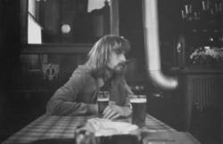 o.T., Junger Mann mit Bierglas in einer Berliner Kneipe.