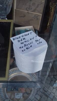 "Spekulationsware Toilettenpapier, sogar im Einzelverkauf: „Highlight, eine Rolle 10 Euro, zwei Blatt 0,50 Euro“", gesehen im Schaufenster eines Antiquitätengeschäfts