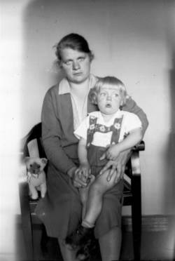 Frau mit Kleinkind, auf Stuhl sitzend