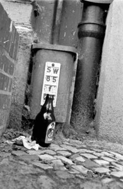 o.T., An einer Haus-Ecke abgestellte Bierflasche
