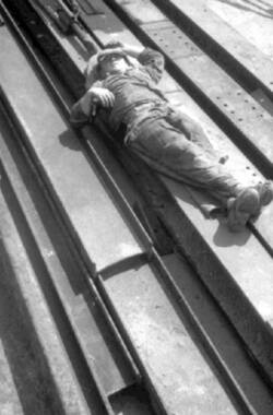 Arbeiter ruht, ausgestreckt auf dem Rücken liegend, auf Stahlträgern
