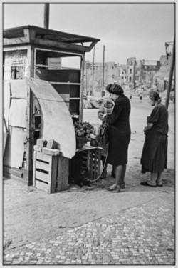 Frauen an einem Blumenstand, behelfsmäßig in einer Telefonzelle eingerichtet