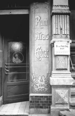 o.T., "Schultheiss"-Kneipe (Hausnummer 54) - alte Jugendstil-Werbung für Arac, Cognac, Rum, rechts Praxis-Schild Dr. med. Franz Jung