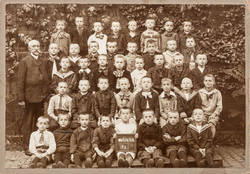 Gruppenbildnis Jungenklasse der 65. Gemeindeschule vor der Schulhof-Mauer