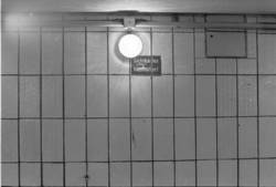 Serie zu Bahnhöfen in Ost-Berlin, VEB Designprojekt im Auftrag des Magistrats von Berlin. Negativ 28 U-Bahnhof Stausberger Platz, Wand mit Lampe und Schild „Sichtkarten hochhalten!“