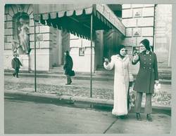 o.T., Tramperinnen mit Einkaufstüten am Straßenrand