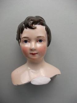 Brustblattkopf, Junge mit welligen Haaren und modellierter Stirnlocke