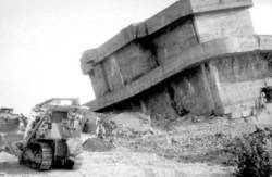 Räumung von Trümmern eines gesprenkten Bunkers mit Baggern.