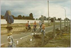o.T., Radfahrer auf dem Grenzstreifen, im Hintergrund die Mauer