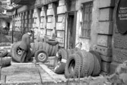 Vor einem Reifendienst lehnen LKW-Reifen an der Hauswand