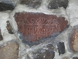 Grundsteinfragment mit Inschrift und vegetabilem Rahmen