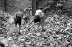 Kinder suchen sich Backsteine in den Trümmerbergen zusammen