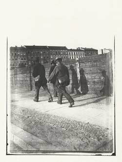 Drei Männer auf dem Heimweg vor einem Zaun in der Sophie-Charlotte-Straße