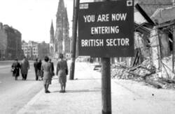 Schild "YOU ARE NOW ENTERING BRITISH SECTOR" in der Tauentzienstraße. Im Hintergrund die Kaiser-Wilhelm-Gedächtniskirche