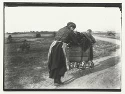 Frau und Kind mit reisigbeladenem Kinderwagen auf dem Weg nach Charlottenburg