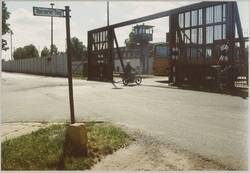o.T., Ein Bus und ein Kleinkraftrad passieren ein Stahltor an der Grenze