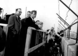 Willy Brandt und John F. Kennedy blicken über die Berliner Mauer. [Repro?]