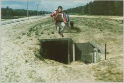 o.T., Kind springt über einen Tunneleingang im Grenzstreifen